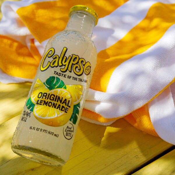 A bottle of Calypso Original Lemonade on a table with a beach towel.