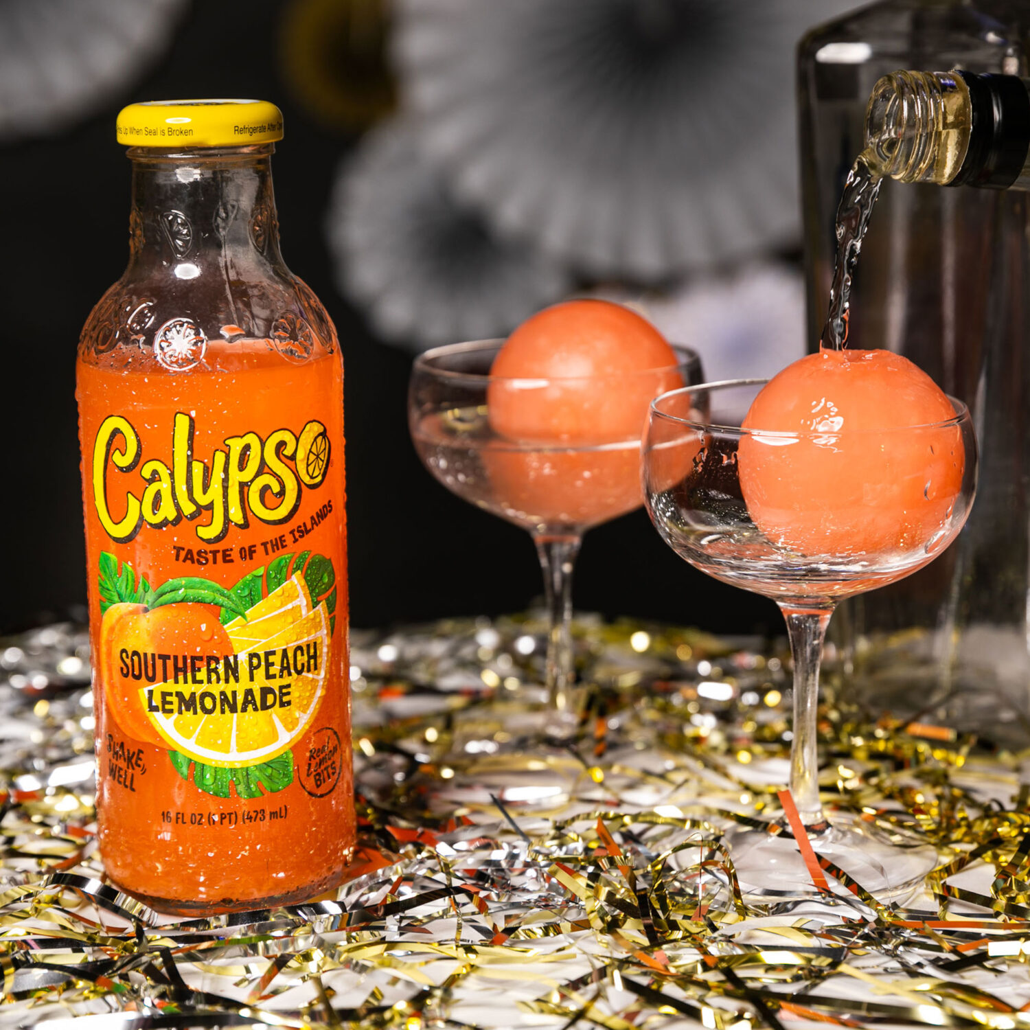 A bottle of Calypso Southern Peach Lemonade on a table next to confetti.