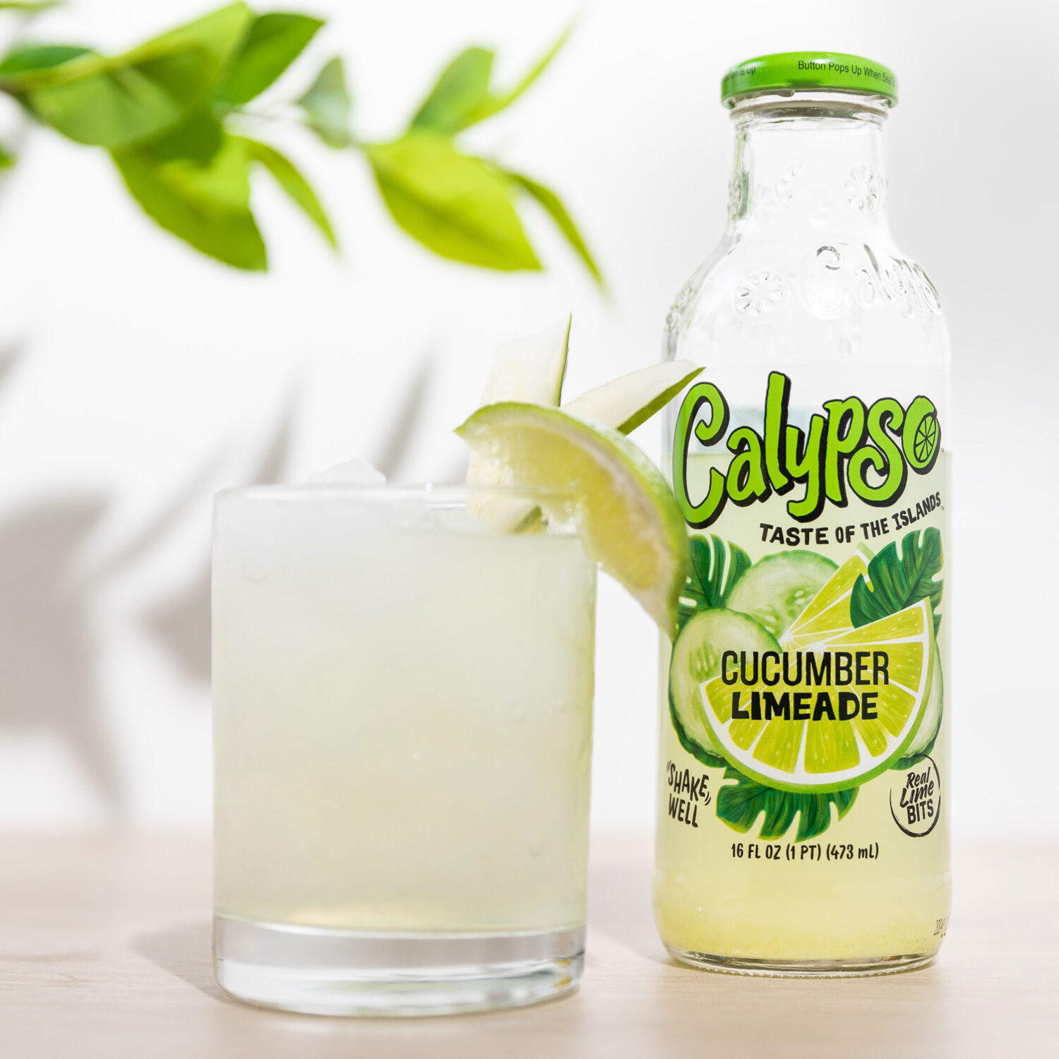 A bottle of Calypso Cucumber Limeade next to a cocktail.