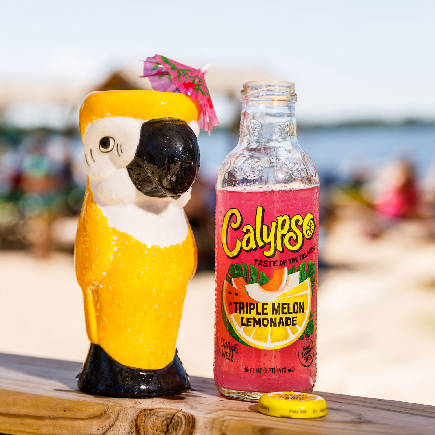 Calypso Triple Melon Lemonade cocktail in a parrot cup with an umbrella.