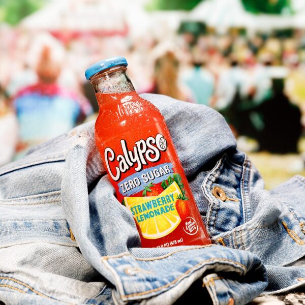 A bottle of Calypso Strawberry Zero Sugar sits on a jean jacket.